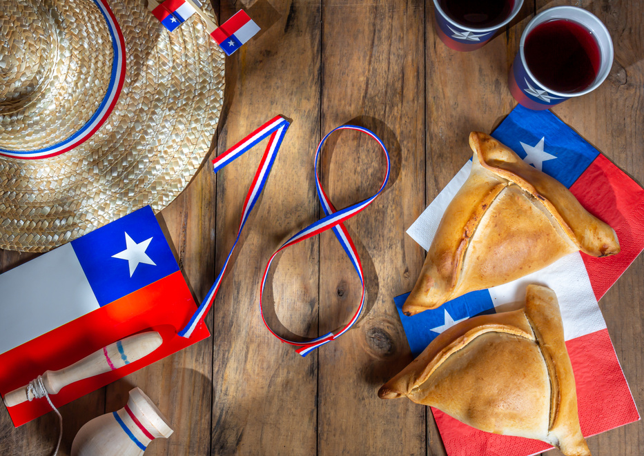Chilean independence day concept. fiestas patrias. Tipical baked empanadas, wine or chicha, fat and play emboque. Decoration for 18 september party day, wooden background, top view